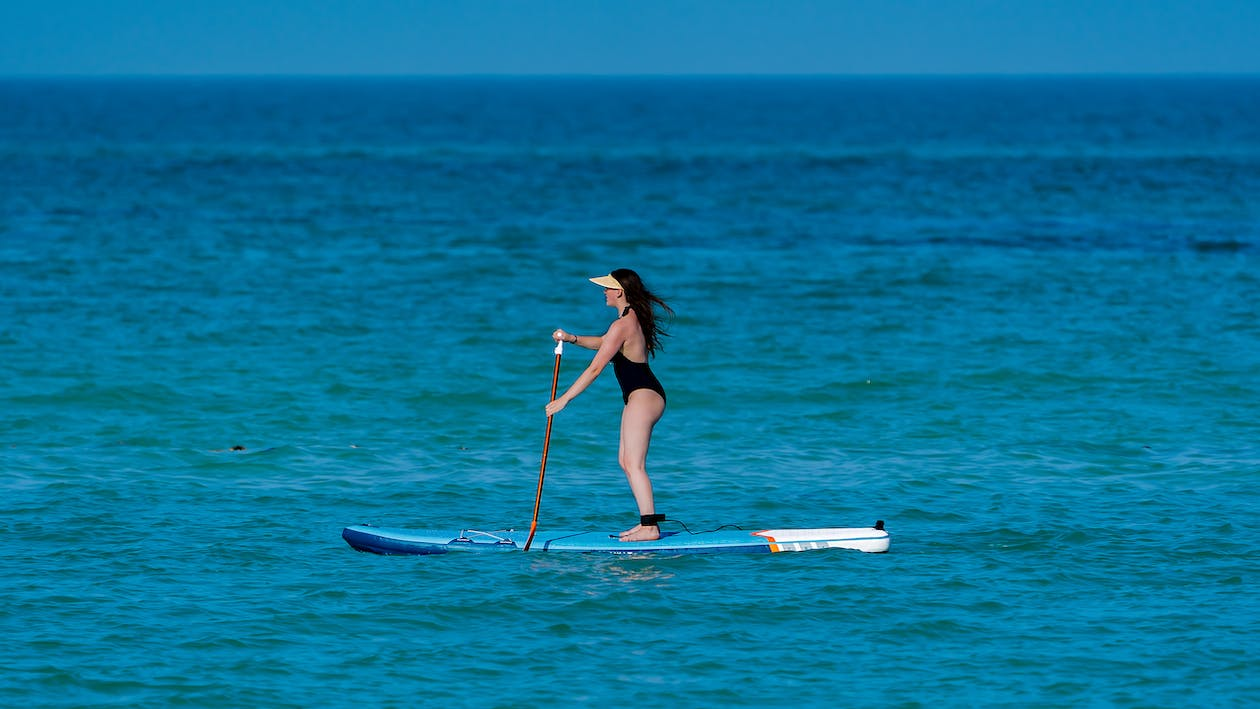 A woman is paddleboarding in the sea 