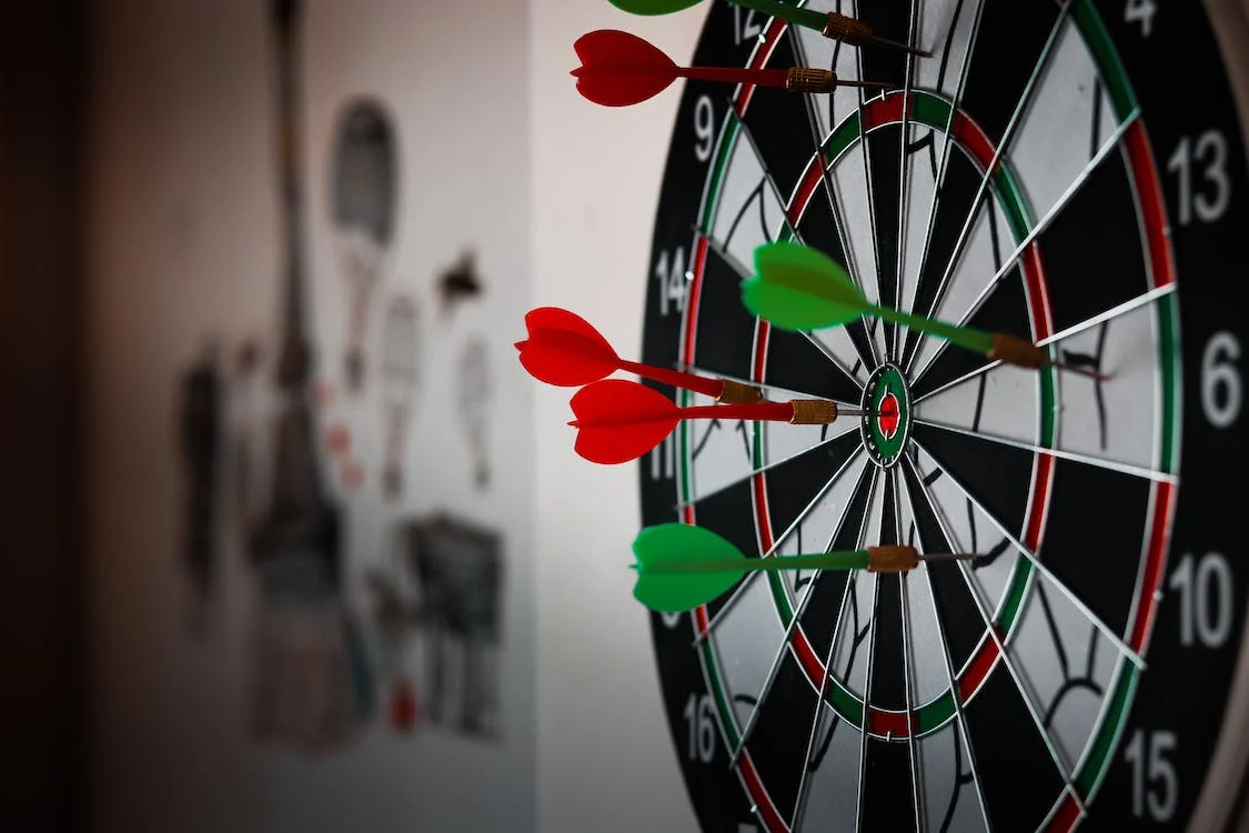 A close-up shot of multiple dart pins on a dartboard 