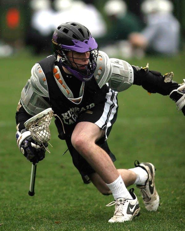 A lacrosse player sprinting after catching the ball in their stick 