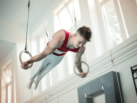 A gymnast practicing using still rings