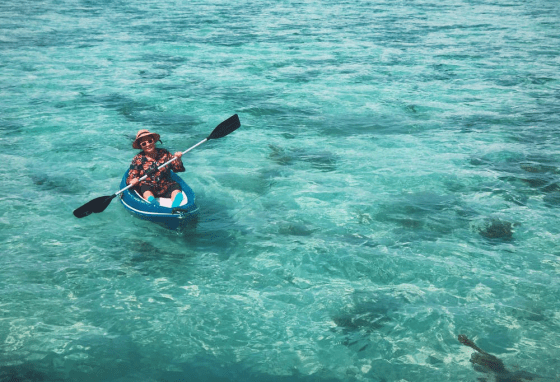 A person enjoying nature while sitting in a blue kayak
