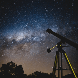A telescope placed under a starry sky