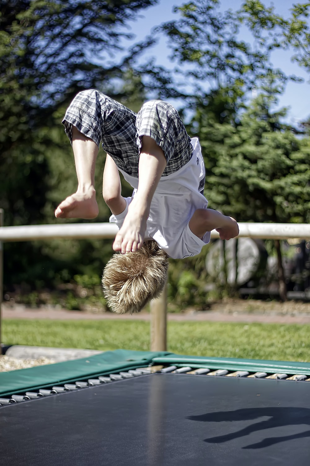 A little boy flipping on their trampoline